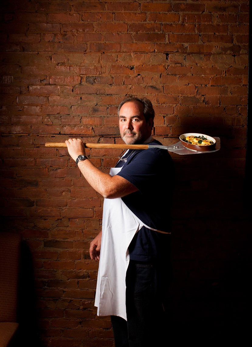 Mark Cupalo Rocco chef owner holds wood fired pizza paddle in Rochester New York